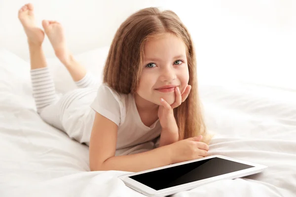 Nettes Kleines Mädchen Spielt Mit Tablet Auf Weißem Bett — Stockfoto