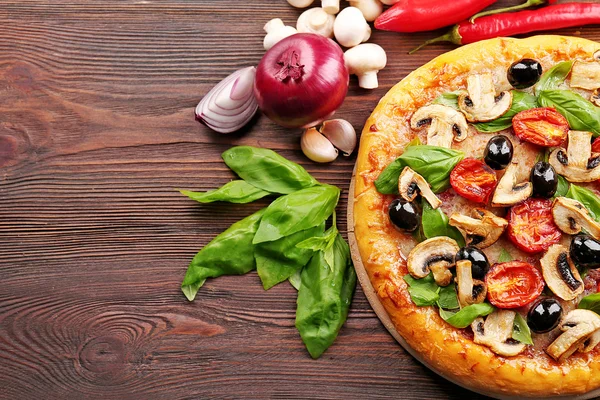 Heerlijke smakelijke pizza met ingrediënten — Stockfoto