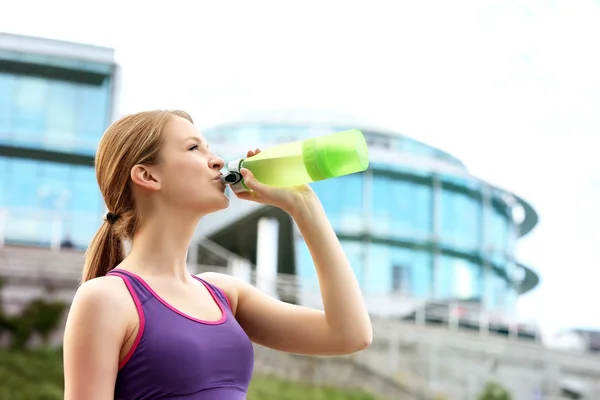 Woman drinking water after jogging — Stock Photo, Image