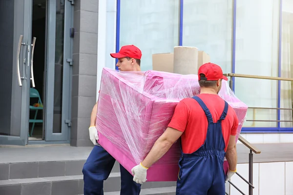 Trabalhadores do sexo masculino com poltrona rosa — Fotografia de Stock