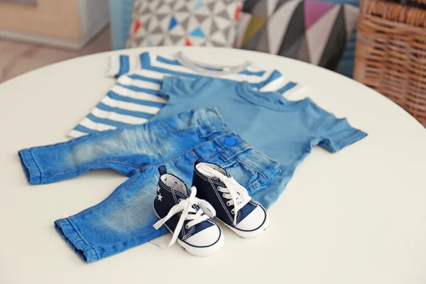 De kleren van de baby op een tafel — Stockfoto