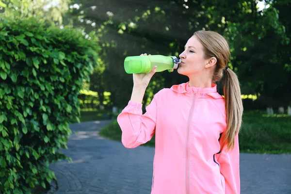 Vrouw drinken water na joggen — Stockfoto