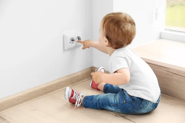 Bebê brincando com tomada elétrica — Fotografia de Stock