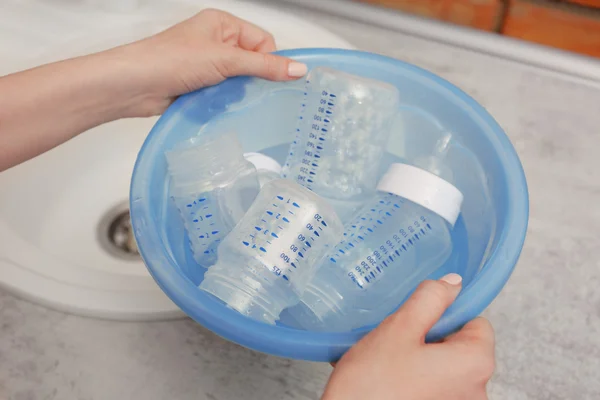 Lavabo azul plástico con biberones —  Fotos de Stock