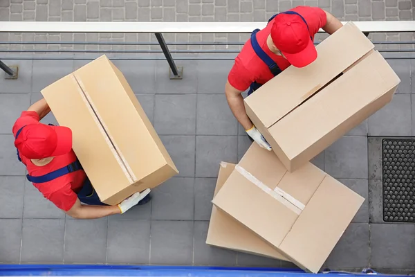 Male workers with heavy boxes — Stock Photo, Image