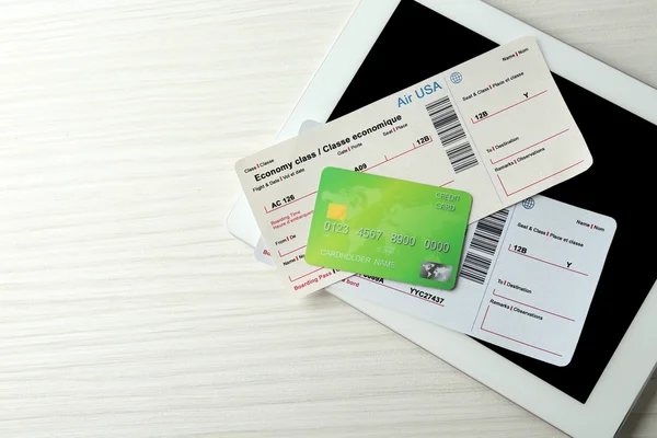 Tableta con tarjeta de crédito y billetes de avión —  Fotos de Stock