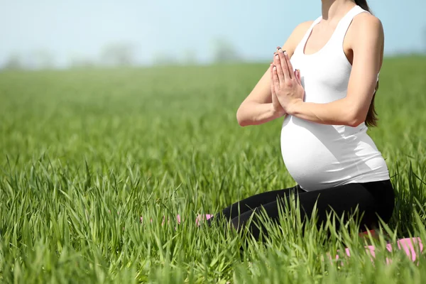 Gravid kvinna praktisera yoga poserar — Stockfoto