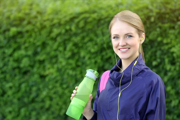 Femme sportive boire de l'eau après avoir fait du jogging au parc par une journée ensoleillée — Photo