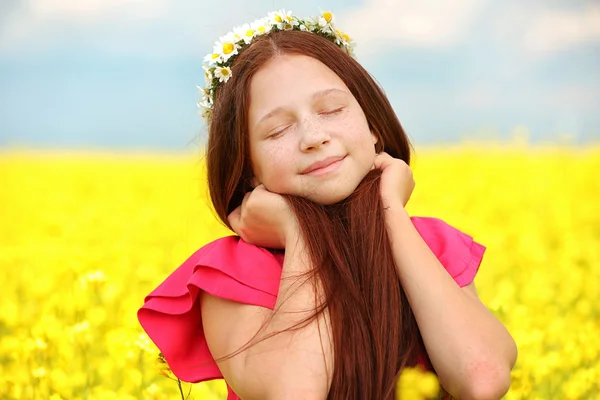 Süßes Mädchen auf der Wiese mit wilden Frühlingsblumen — Stockfoto