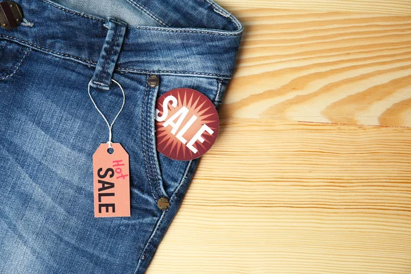 Female jeans on wooden table — Stock Photo, Image