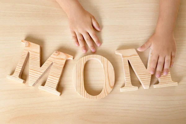 Palavra mãe e as mãos da criança — Fotografia de Stock