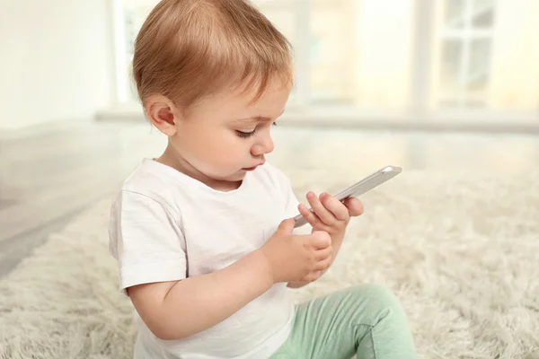Милая девочка играет со смартфоном — стоковое фото