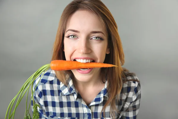 Schöne Mädchen essen Karotte — Stockfoto