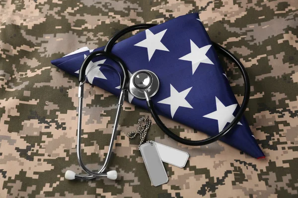Stethoscope and army token on American flag — Stock Photo, Image