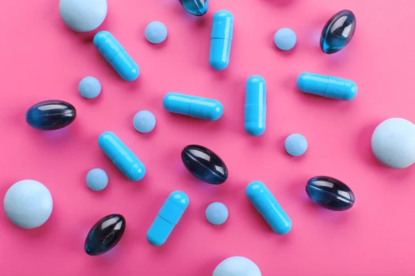Pillole blu su rosa — Foto Stock