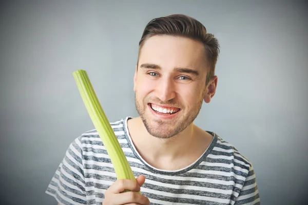Handsome man eating celery — Stock Photo, Image