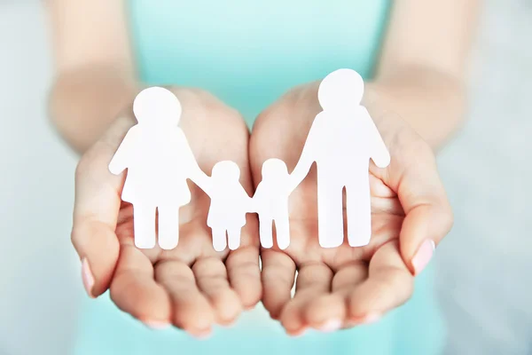 Female hands with paper family — Stock Photo, Image