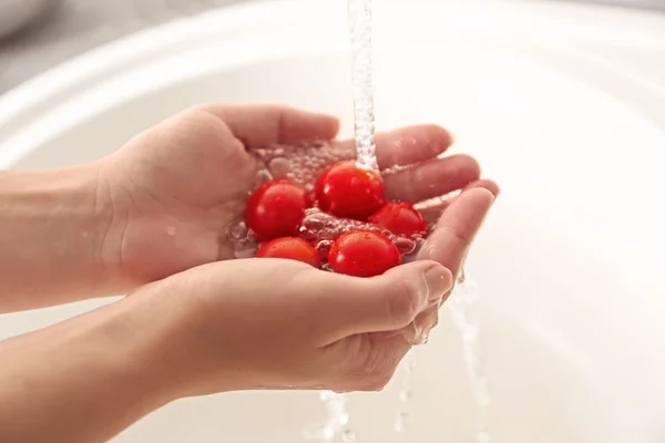 Mãos lavando tomates cereja — Fotografia de Stock