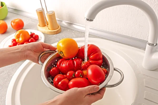 Washing tomatoes in colander — Stock Photo, Image
