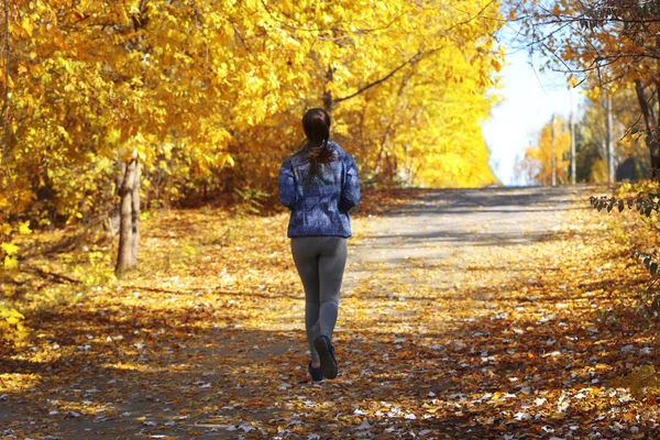 Woman jogging in autumn park — Stock Photo, Image