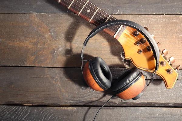 Gitarre und Kopfhörer auf Holz — Stockfoto