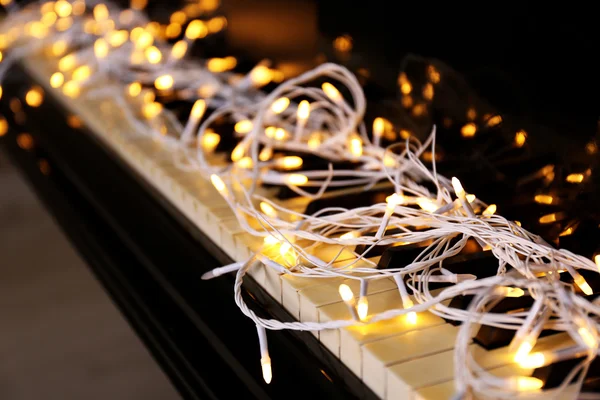 Christmas lights on piano — Stock Photo, Image