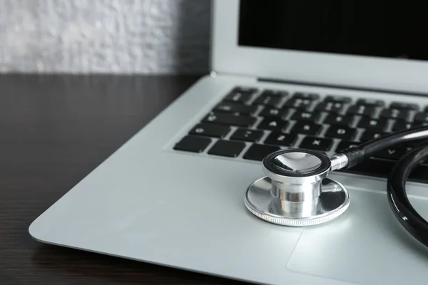 Laptop mit Stethoskop auf dem Tisch — Stockfoto