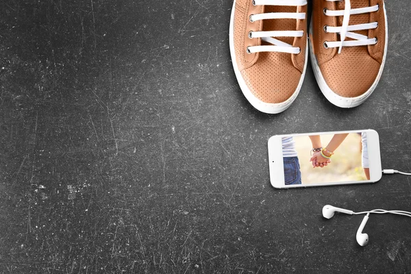 Серая обувь и мобильный телефон — стоковое фото