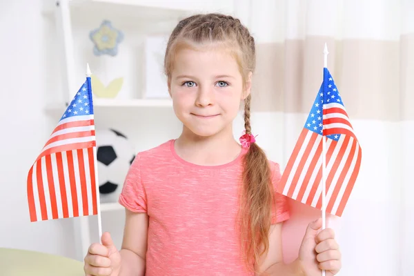 Niña sosteniendo banderas americanas — Foto de Stock