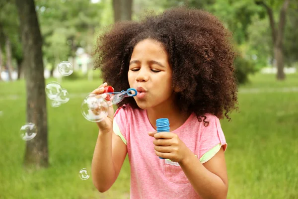 little girl blowing soap bubbles