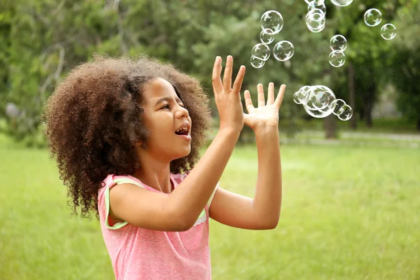 Klein meisje vangen zeepbellen — Stockfoto