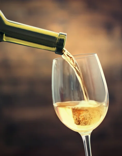 White wine pouring in glass — Stock Photo, Image