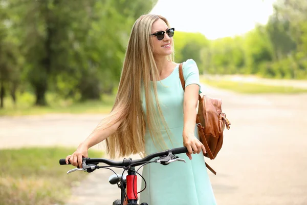 Красивая девушка с велосипедом на улице — стоковое фото