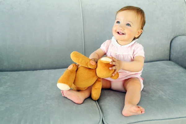 Baby sitting with teddy bear — Stockfoto