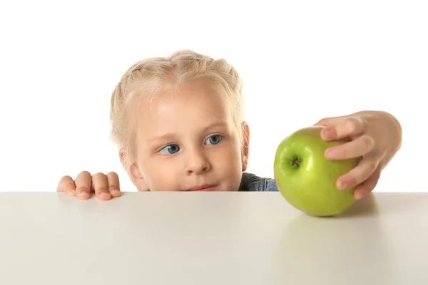 Funny little girl looking at apple — Stock Photo, Image