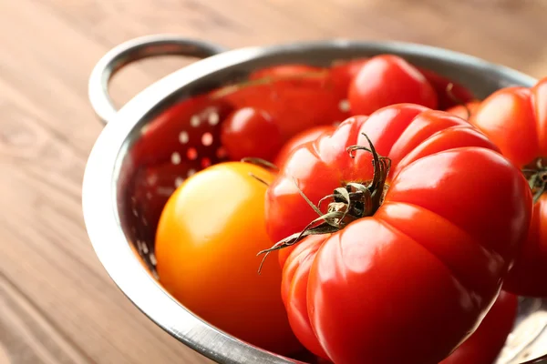 Different tomatoes in colander — Stock Photo, Image