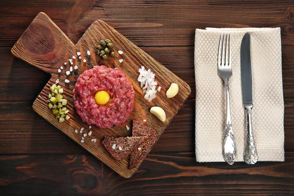 Steak Tatar mit gehackten Zwiebeln und Essiggurken auf einem Tablett — Stockfoto