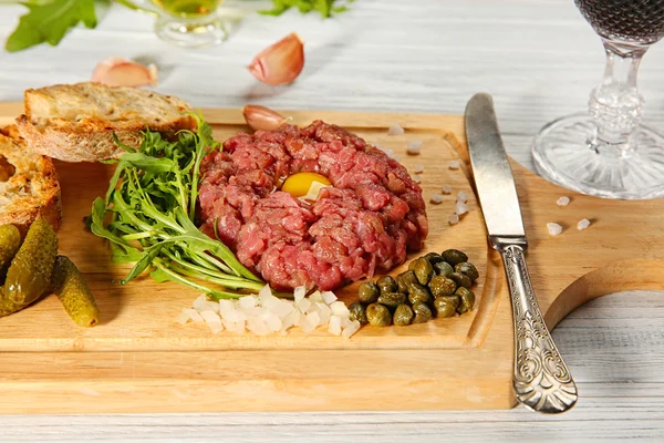 Steak tartar dengan onio cincang dan acar di atas nampan — Stok Foto