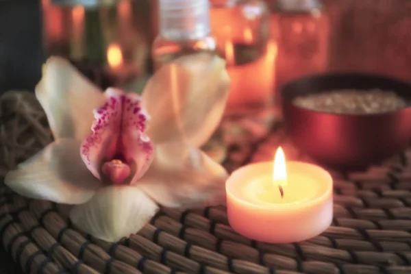 Piękny kwiat orchidei i zapaloną świecą — Zdjęcie stockowe