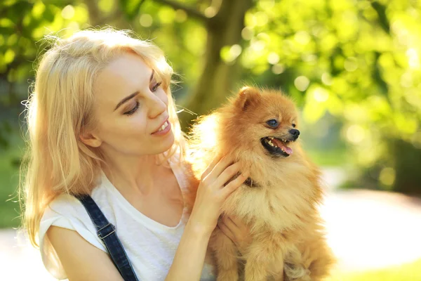 Vrouw bedrijf pluizige hond — Stockfoto