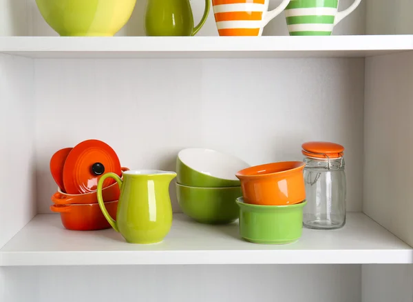 Tableware on shelves in cupboard