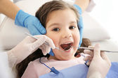Dentist examining girls teeth