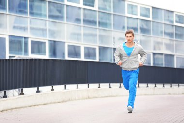 Genç adam koşuyor. 