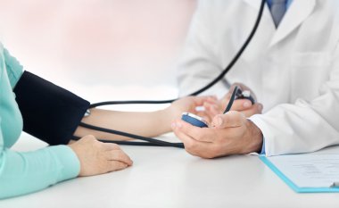 Doktor kan basıncını ölçüyor.