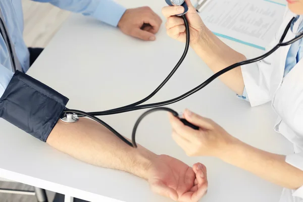 Médico midiendo presión arterial —  Fotos de Stock