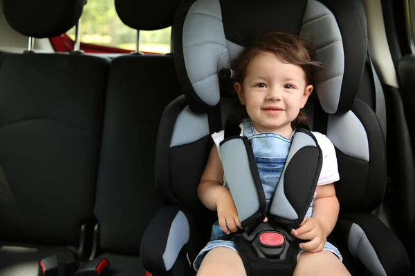 Мальчик, сидящий в машине в кресле безопасности — стоковое фото