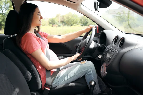 Mujer embarazada conduciendo coche — Foto de Stock