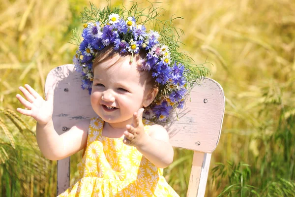Bébé fille avec couronne de fleurs sauvages — Photo