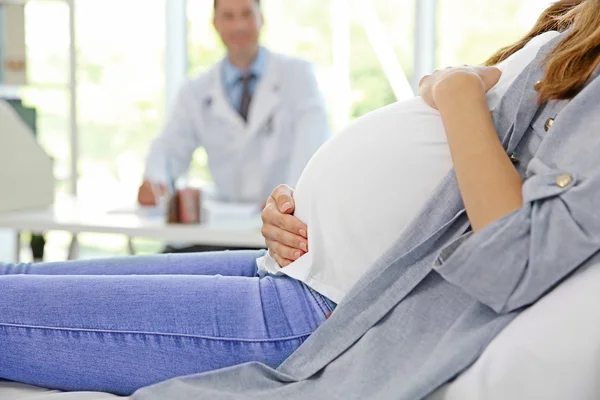 Grávida jovem mulher visitante médico — Fotografia de Stock