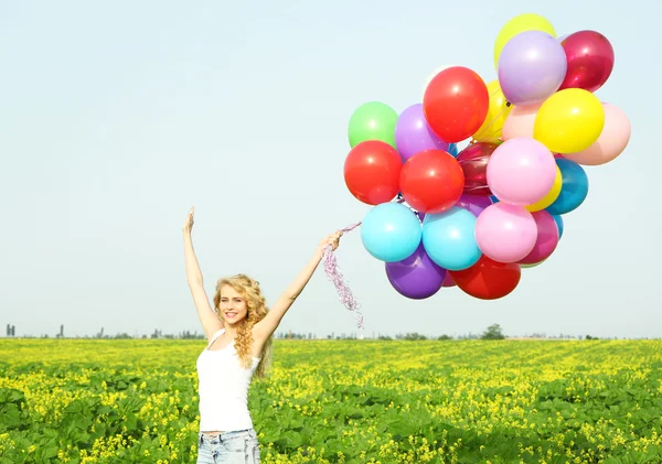 Femme heureuse avec des ballons colorés — Photo